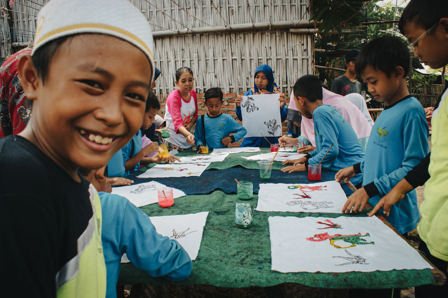 Students smiling while creating art together in an outdoor learning activity